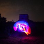 Vivid purple and pink light orb in front of WWII radar bunker at night