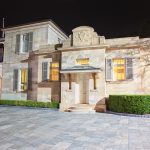 Nighttime photo of historic QUT Brisbane building with sandstone façade, pillars, and warm lighting