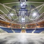 Interior of the South Bank Piazza in Brisbane with empty stage, blue seating, and overhead steel lighting rig